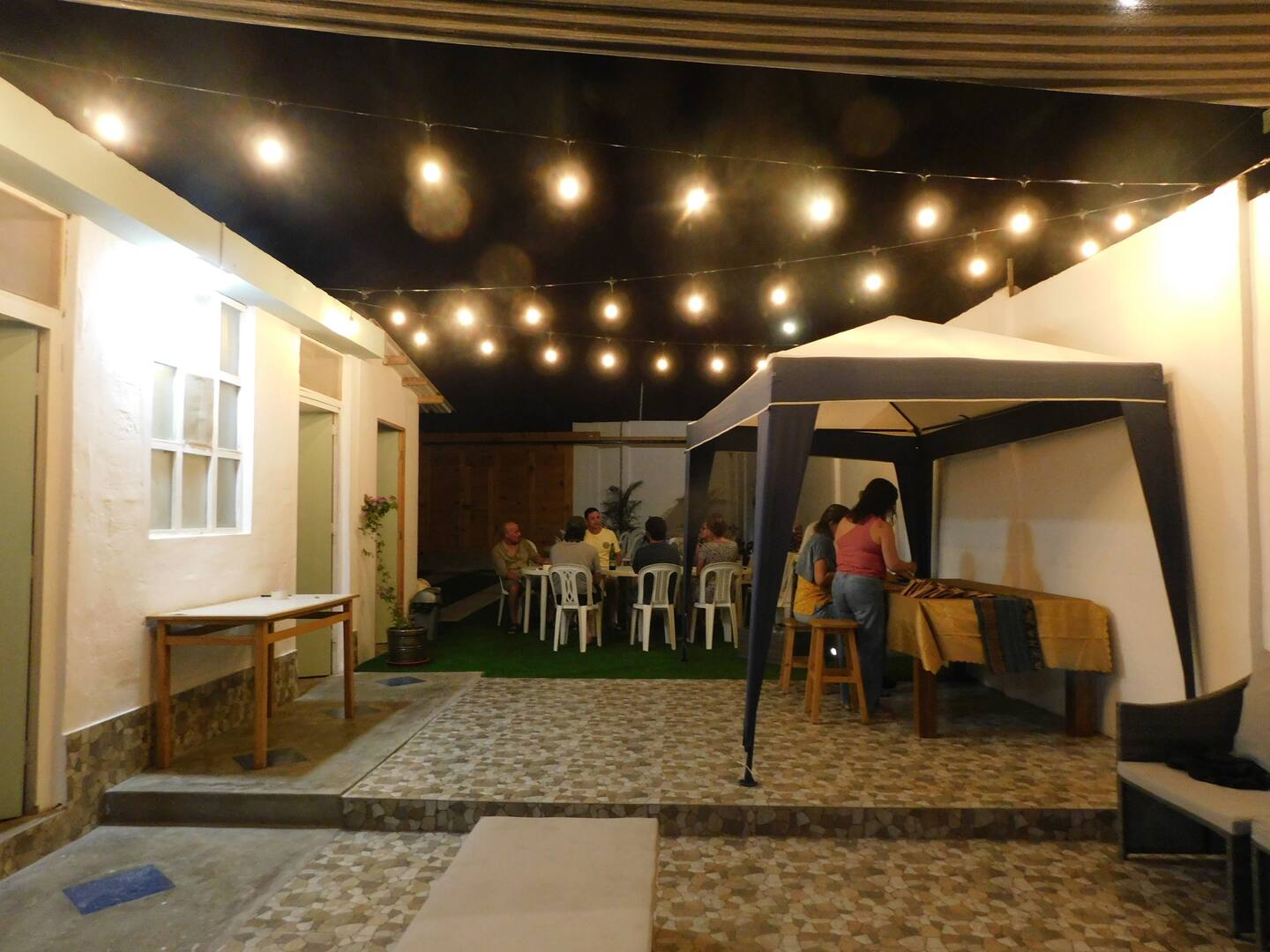 Reunión nocturna en el patio bajo luces cálidas
